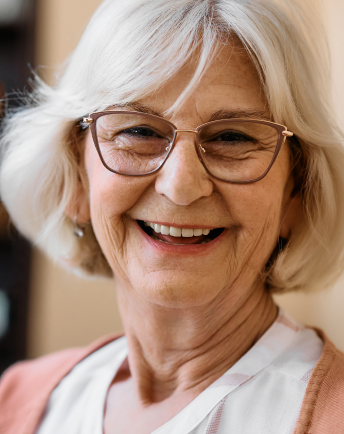 Elderly woman smiling after treatment at Alora Dental