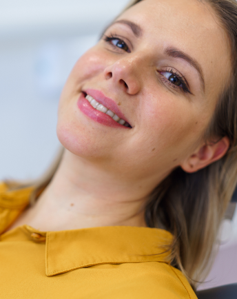 A woman smiling while being treated